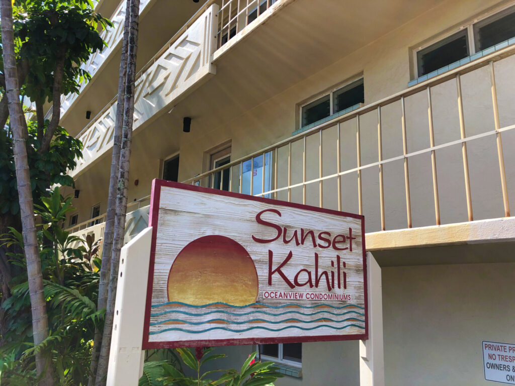 Sunset Kahili sign in front of it's building