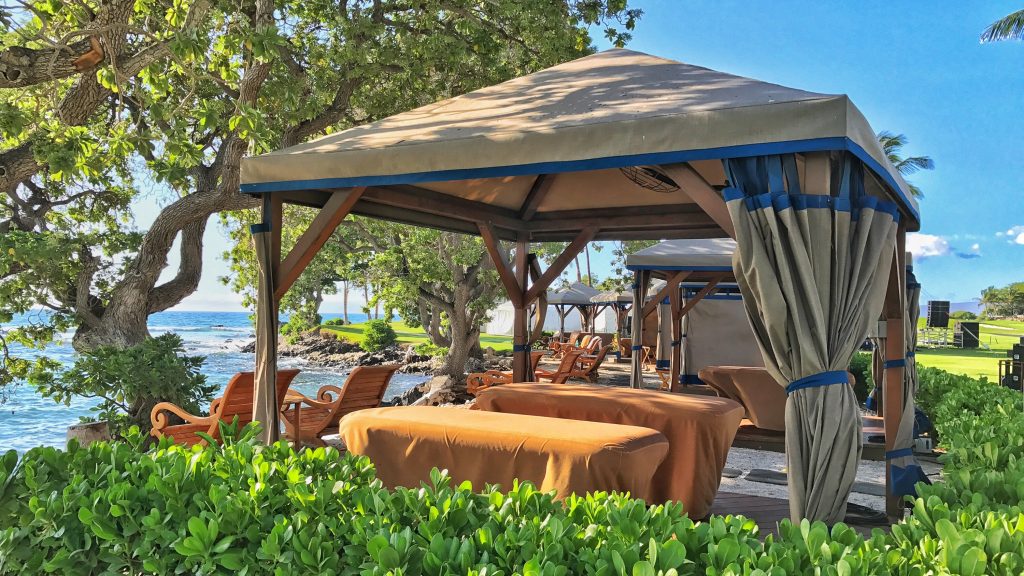 Located on Hawaii Island's Kohala Coast, Fairmont Orchid luxury beach resort and spa presents a outside viewing era with a tent and wooden chairs that's surrounded by nature