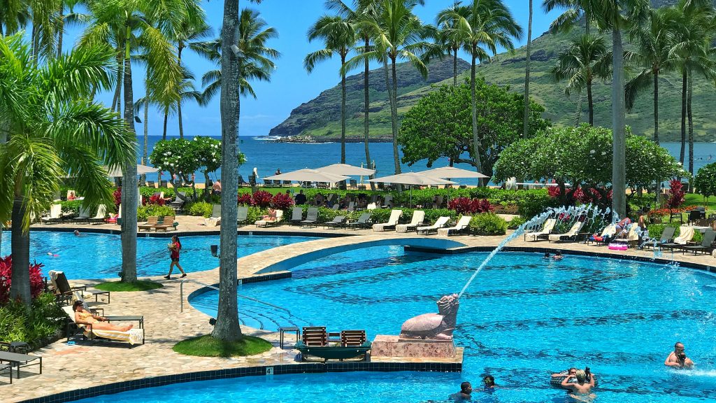 Overlooking the serene Kalapaki Beach on the Pacific Ocean, the Kauai Marriott Resort & Beach Club features a pool where guests can be seen enjoying various swimming activities.