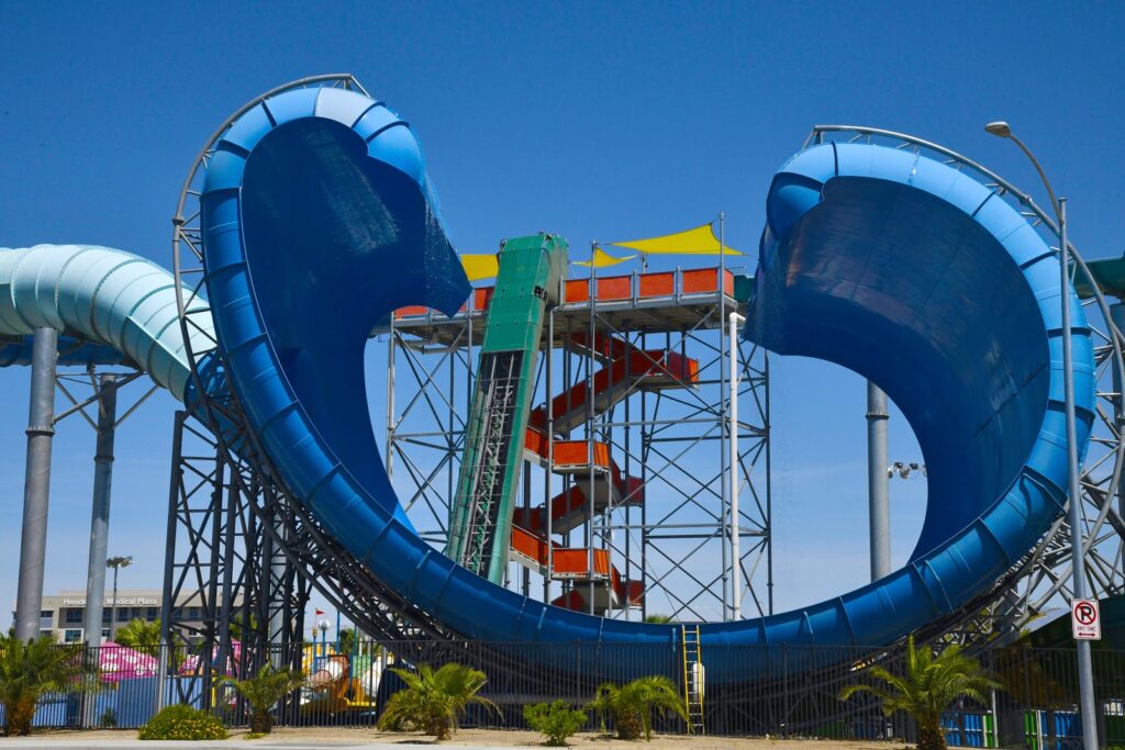 A Las Vegas Waterpark's view of a big blue slide that both of the ends curve into each other