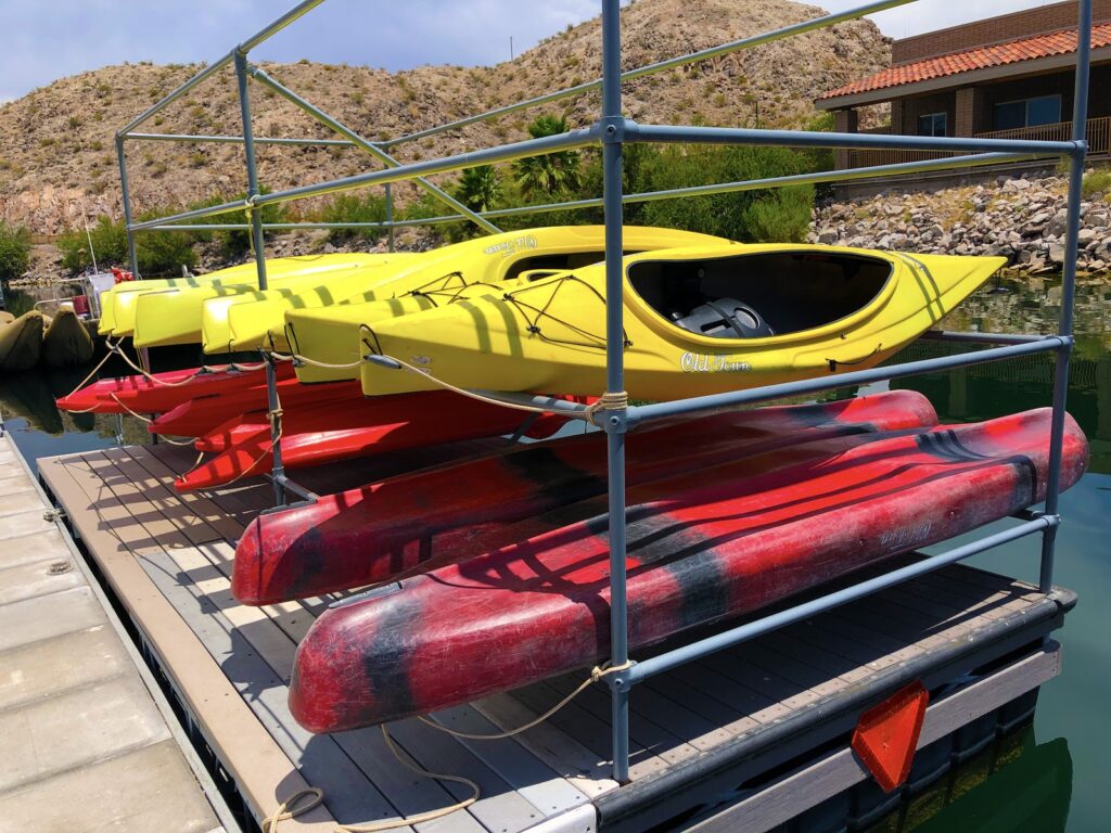 Yellow Kayaks on top and Red Kayaks on bottom of the storage unit on top of a dock