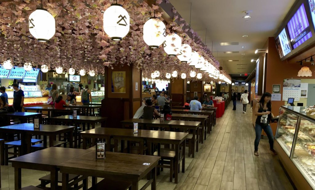 In side the restaurant of Shirokiya, Sakura blossom petals and lamps hanging from the ceiling and wooden floors and tables. It's located in Honolulu, Hawaii