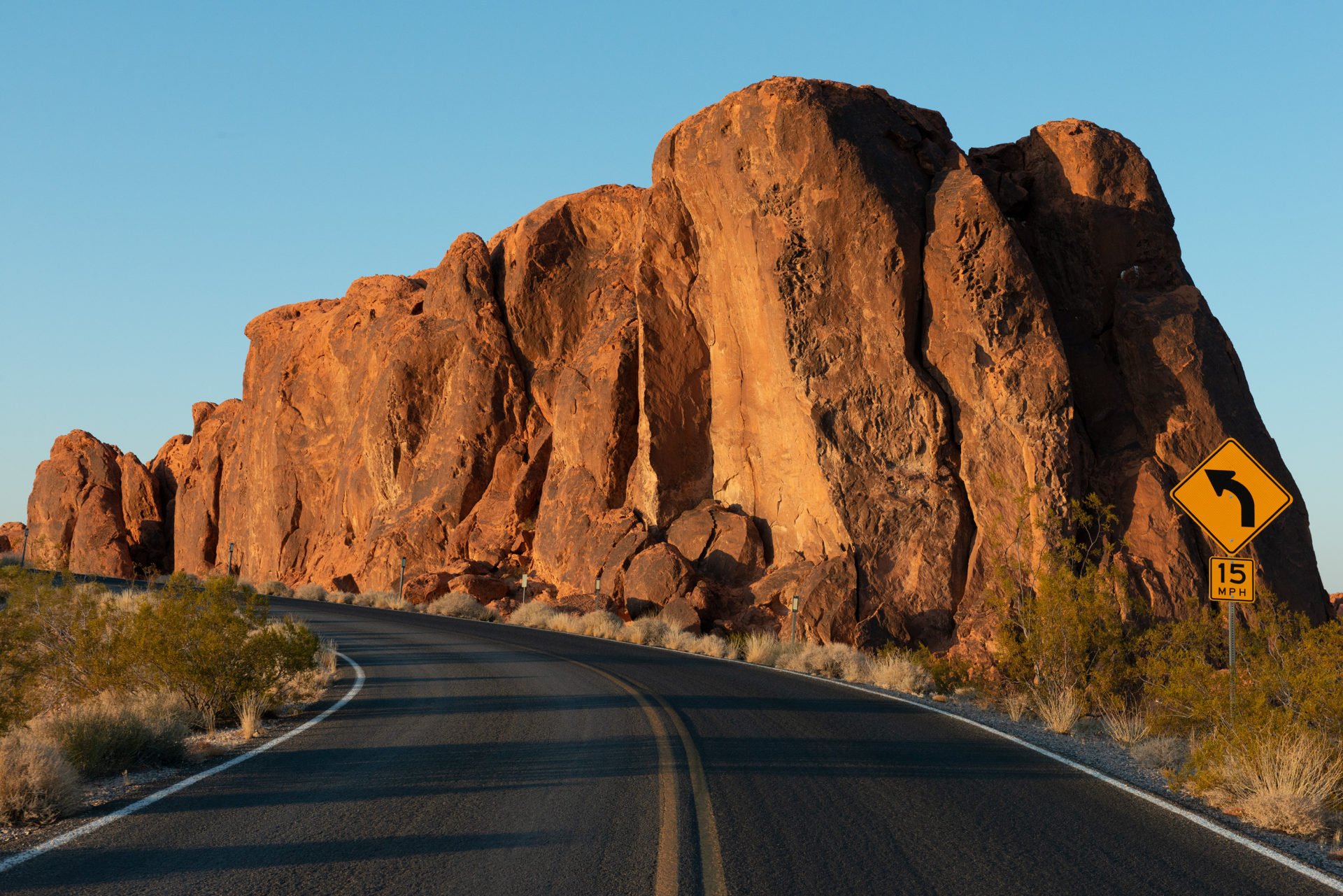 Valley of Fire State Park showing off it's crimson-hued rock formations and sandstone cliffs while a road is running towards the camera