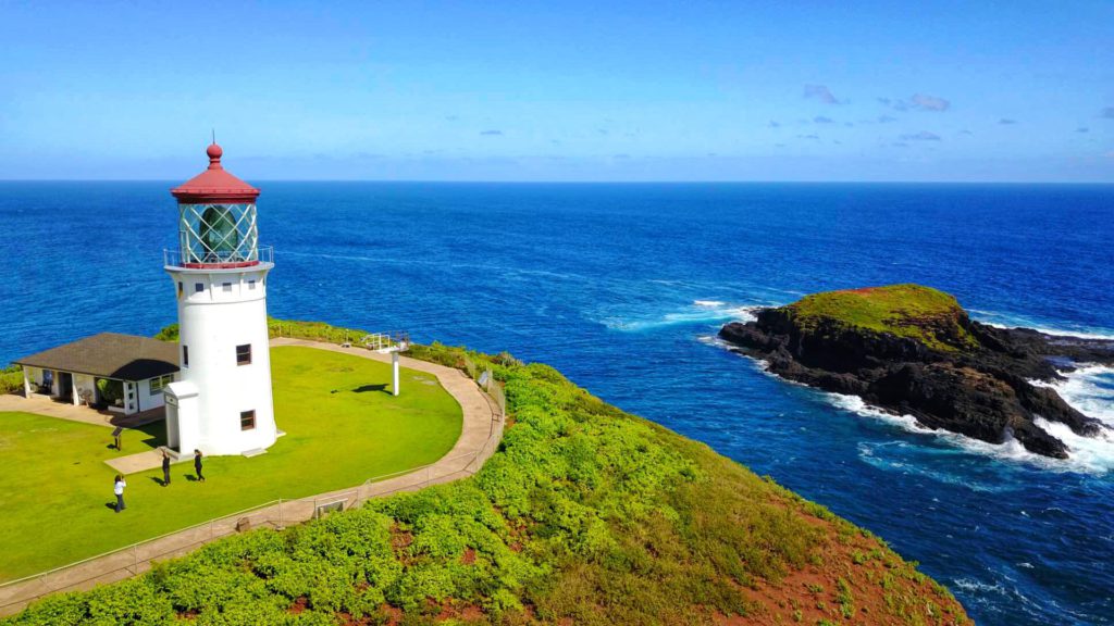 The Kilauea Lighthouse stands on a beacon rugged cliffs, its white tower contrasting against the deep blue ocean in the background on the northern coast of Kauai, Hawaii