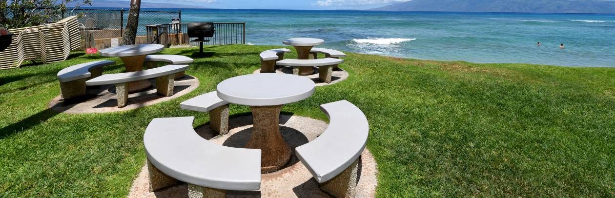 Hale Mahina Beach Resort open area with chairs and tables next to the beach