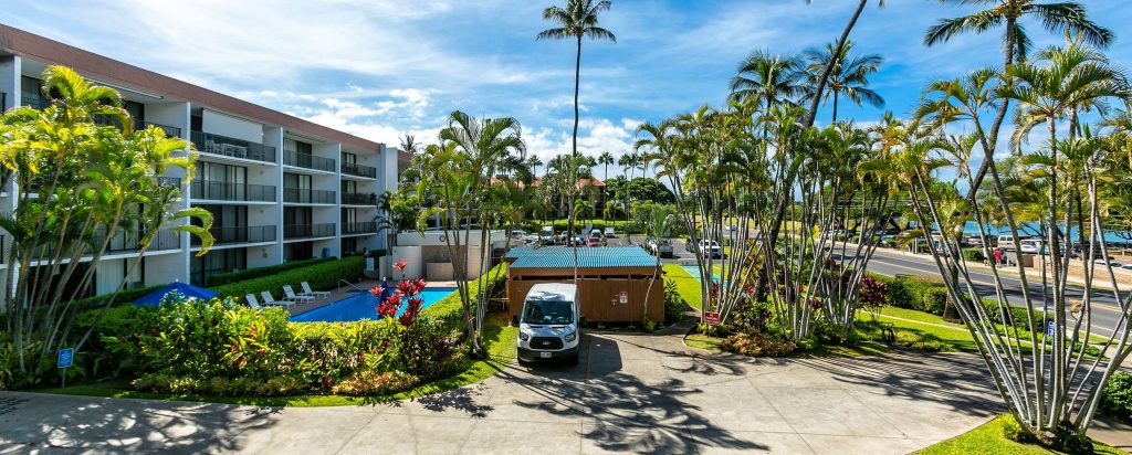 Wide view of Maui Parkshore with the buildings, pool, parking lot and road in the camera shot