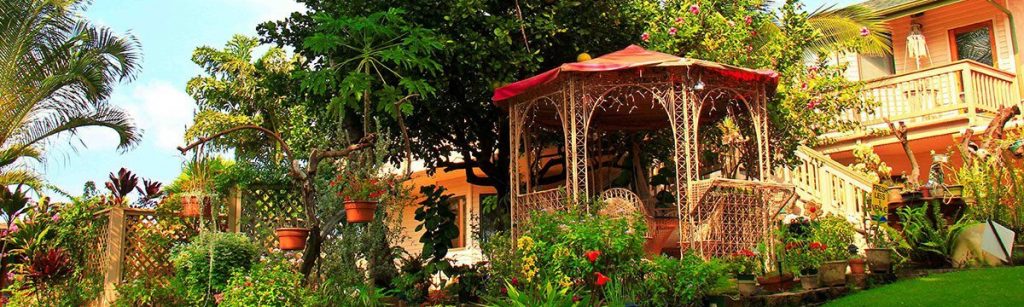 Nona Lani Cottages view on the side with a decorative gazebo covered in plants near the camera