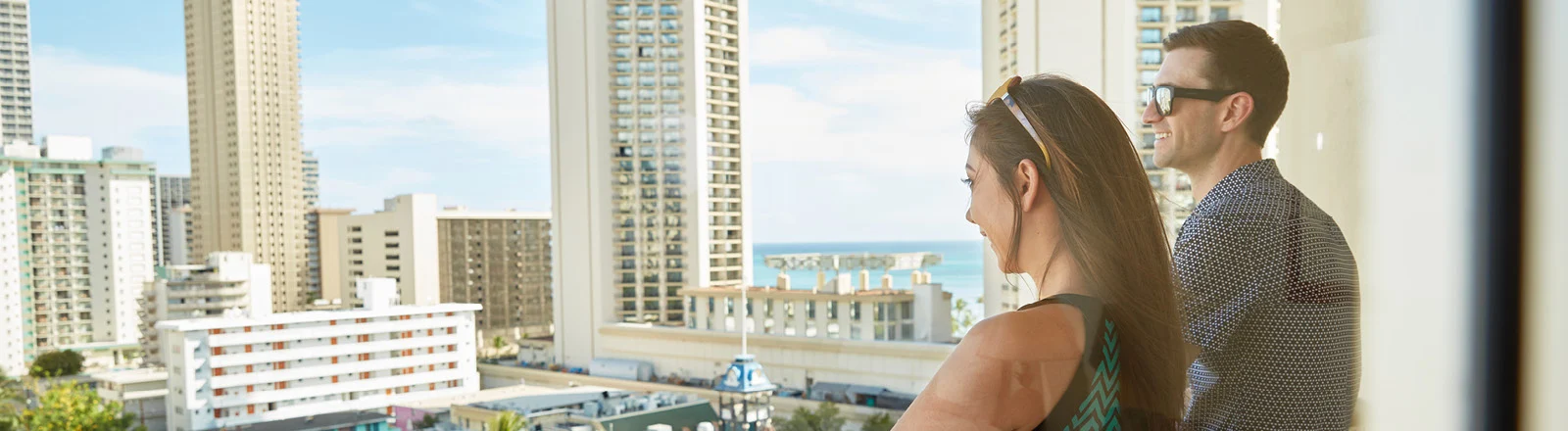 Two people on the Ohana Waikiki East balcony looking out at the city landscape