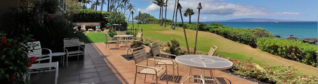 Open area of Punahoa where beach chairs and table are on a flat surface and the beach can be seen in the background