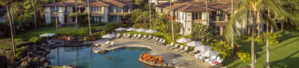 Far view of Wailea Beach Villas poolside and chairs lined up around the side