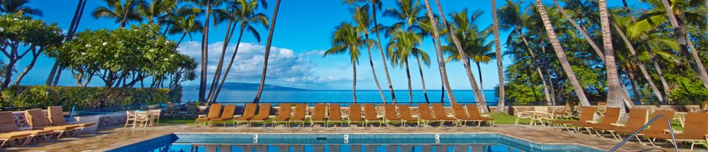 Wailea Elua Village poolside with trees and chair align the side