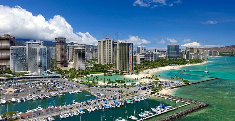 A far view of Ilikai Hotel & Suites in Waikiki city with the beach and ocean on the side