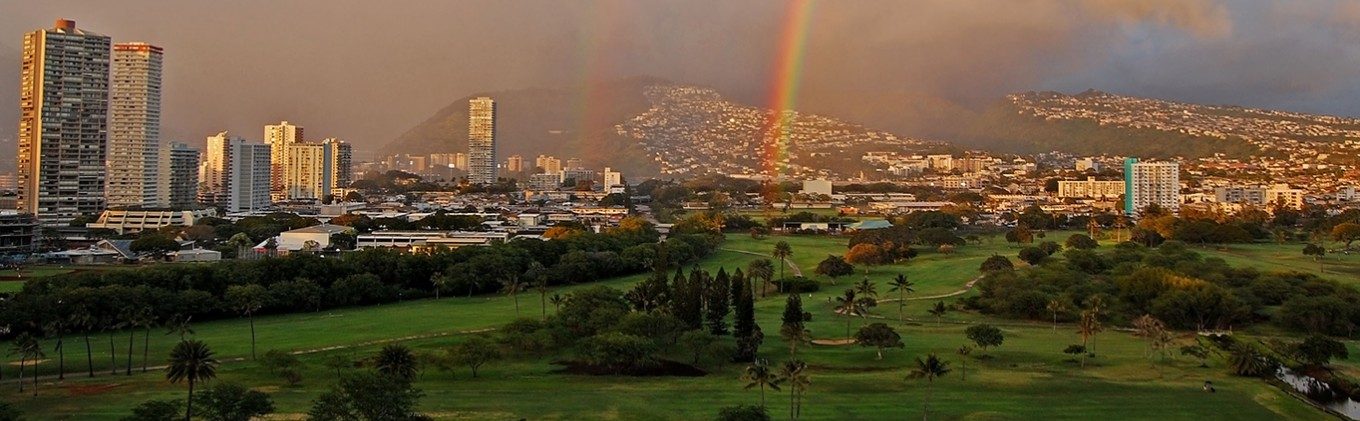 Ilima Hotel outside view with nature, waikiki city, and a rainbow