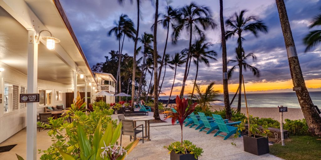A view of Ke Iki Beach Bungalows' open area with the buildings lights on