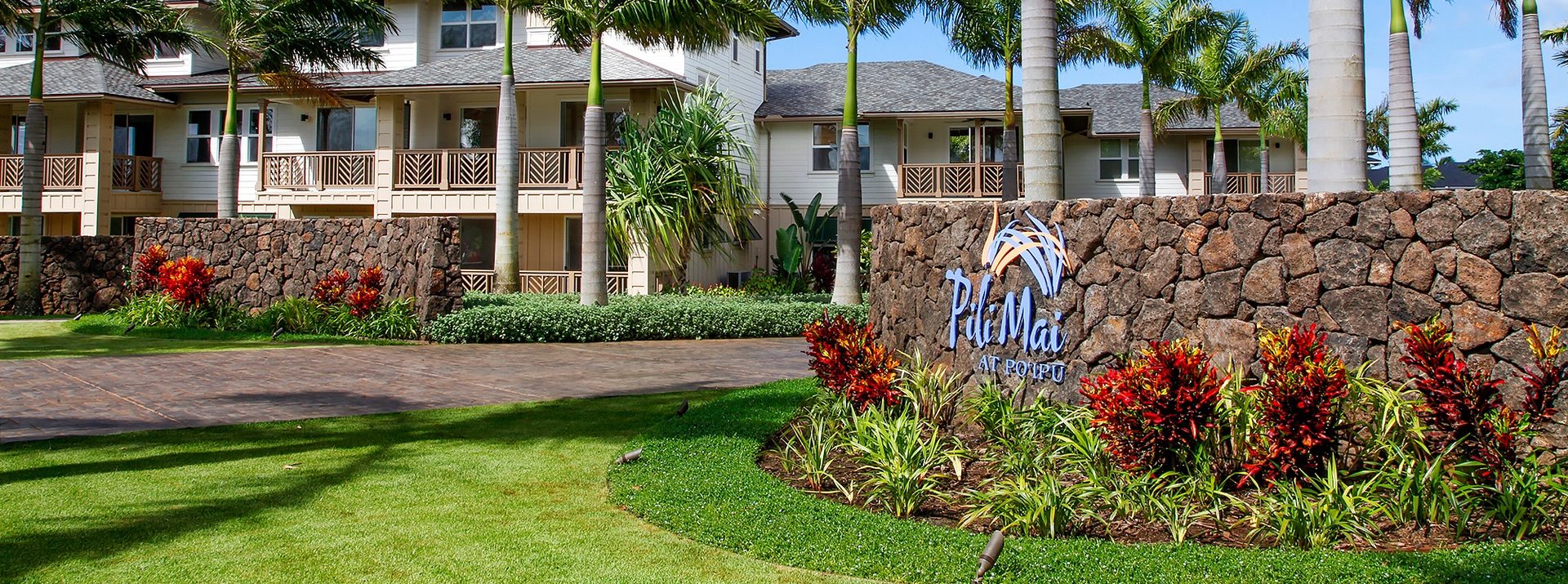 The front building view of Pili Mai at Po‘ipu with the logo on the right