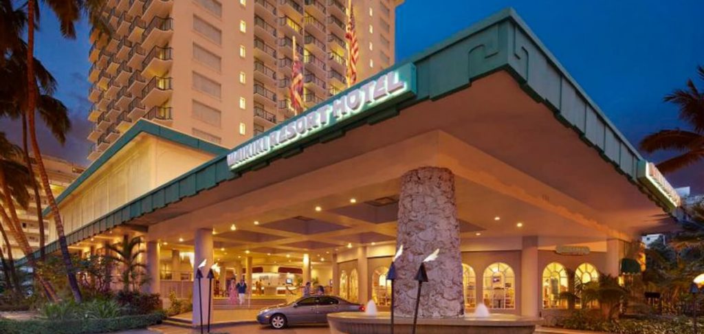 Waikiki Resort Hotel at night with all the lights on and the acrylic white letter logo sign shown