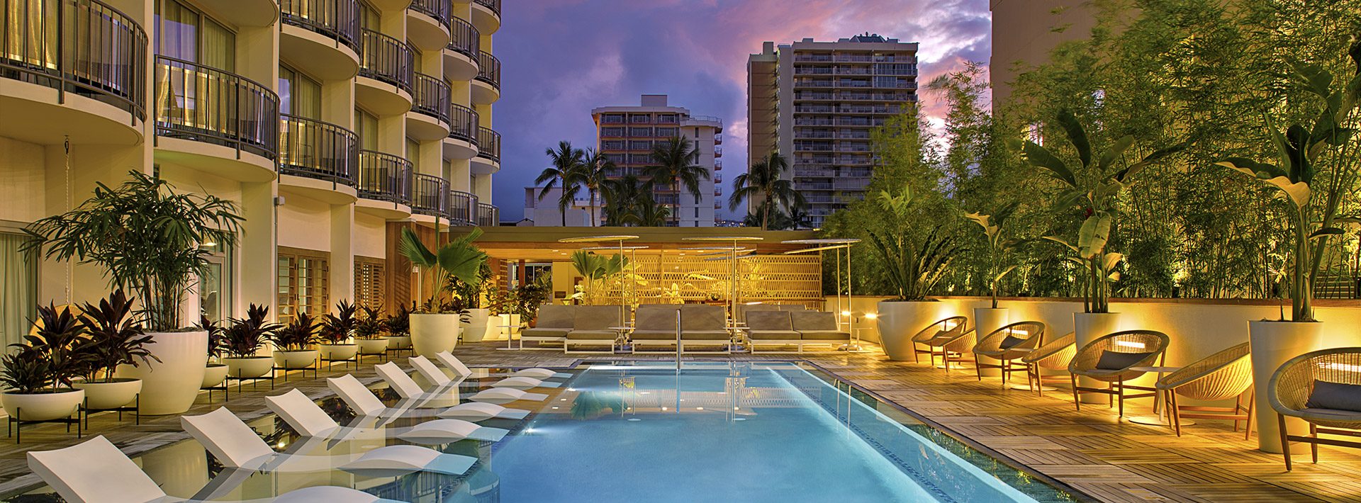 The Laylow Autograph Collection poolside with the chairs lined up in the pool's elevated side and outside the pool