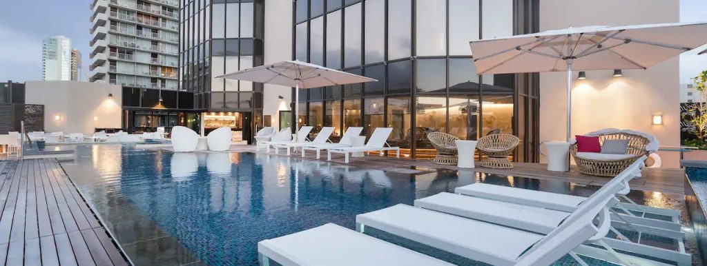 Hyatt Centric Waikiki Beach pool with chairs along the side