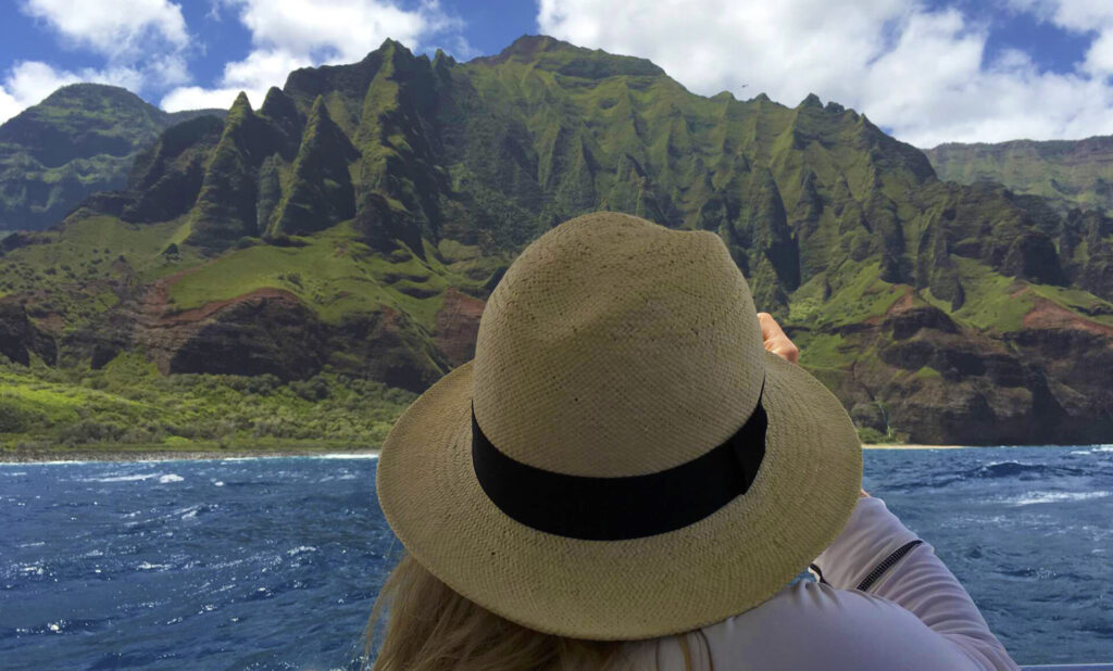 The most enjoyable way to explore the Na Pali coast is by participating in a helicopter or boat tour, which provides excellent views of the cliffs, sea caves, and allows for snorkeling opportunities on various types of boats such as sailing catamarans, power catamarans, or rigid hull inflatables. 