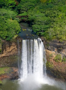 A view of Kauai falls with water pouring down into a body of water